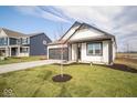 Charming two-story home with white siding and a gray roof, situated on a well-maintained lawn at 5559 Tart Blvd, Indianapolis, IN 46239
