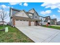 Two-story home with gray siding, brick facade, and a spacious driveway at 2447 S Copperstone Dr, New Palestine, IN 46163