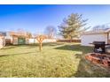 Spacious backyard with shed, fire pit, and plenty of grass at 6908 Jackson St, Anderson, IN 46013
