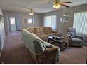 Living room featuring carpeted floors, a sectional sofa, recliner, and coffee table at 1517 N E St, Elwood, IN 46036