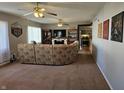 Living room with plush carpeting, a sectional sofa, and a view into the kitchen at 1517 N E St, Elwood, IN 46036