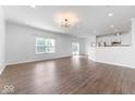 Open-concept living room with hardwood floors, white walls, and access to the kitchen at 1939 Archbury Dr, Avon, IN 46123