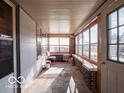 Bright sunroom with large windows, brick accents, and a door to the outside at 1115 N Kealing Ave, Indianapolis, IN 46201