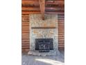 Stone fireplace with wood stove in a rustic log cabin setting at 4298 W 300 N, Anderson, IN 46011