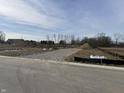 Empty lot with gravel driveway and mounds of dirt, ready for new construction at 2974 S Kings Way, New Palestine, IN 46163