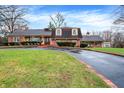 Brick house with a large, curved driveway and landscaping at 6337 Cardinal Ln, Indianapolis, IN 46220