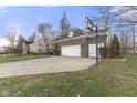 Three-car garage with a basketball hoop, and a spacious driveway at 702 Chestnut Dr, Avon, IN 46123