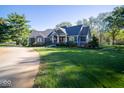 Ranch style home with large windows and a curved driveway at 13829 N Gray Rd, Carmel, IN 46033