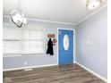 Bright entryway with blue door, hardwood floors, and a coat rack at 1535 N Glen Arm Rd, Indianapolis, IN 46214