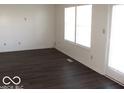 Living room with dark laminate floors and large windows at 10604 Creekside Woods Dr, Indianapolis, IN 46239