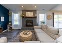 Cozy living room featuring a fireplace, hardwood floors, and ample natural light at 11560 Cherry Blossom West Dr, Fishers, IN 46038