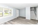 Bright living room with gray walls, wood-look floors, and staircase at 2451 Sickle Rd, Indianapolis, IN 46219