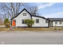 White house with an orange door, showcasing modern updates and curb appeal at 501 Madison Ave, Arcadia, IN 46030