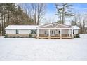 Charming farmhouse exterior, covered porch, snowy landscape at 5311 W Jackson St, Muncie, IN 47304