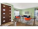 Modern living room with a navy sectional sofa and orange accent chairs at 6675 Amherst Way, Zionsville, IN 46077