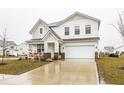 Two-story house with gray and white siding, a large driveway, and landscaping at 2546 Mounts Run Ln, Whitestown, IN 46075