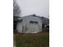 Side exterior view of a single-story home with a detached garage at 603 W Broadway St, Alexandria, IN 46001