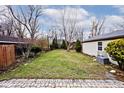 Large backyard with grassy area and brick patio at 6348 Kingsley Dr, Indianapolis, IN 46220