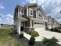 Two-story townhome with gray siding, white garage door, and landscaping at 9592 Beckett St, Avon, IN 46123