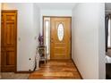 Front entry with wood flooring, decorative side table, and an oak door at 965 W New Rd, Greenfield, IN 46140