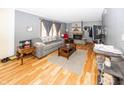 Living room with hardwood floors, stone fireplace, and comfortable gray couch at 965 W New Rd, Greenfield, IN 46140