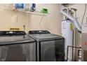 Laundry room with front-loading washer and dryer, water heater, and storage shelf at 1633 Park Ridge Way, Indianapolis, IN 46229