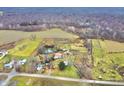 Aerial view of a property with a house, barn, pond, and expansive land at 7021 Bellsville Pike, Columbus, IN 47201