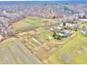 Aerial view showing a large property with farmlands, a pond, and multiple buildings at 7021 Bellsville Pike, Columbus, IN 47201