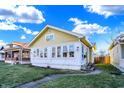 Charming yellow home with a green lawn, walkway, and fenced side yard at 2335 Union St, Indianapolis, IN 46225