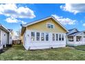 Charming yellow home with a green lawn and a view of the neighboring homes at 2335 Union St, Indianapolis, IN 46225