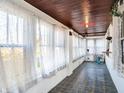 Sunroom with white brick walls, large windows, and gray tile flooring at 2335 Union St, Indianapolis, IN 46225