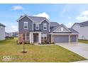 Inviting two-story home with a three-car garage and a landscaped front lawn at 5655 Lighthouse Dr, Brownsburg, IN 46112
