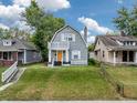 Charming two-story home with a welcoming orange door, small porch, and grassy front yard at 1125 Congress Ave, Indianapolis, IN 46208