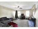 Cozy living room with a sectional sofa, ceiling fan, and Christmas tree at 2082 Shadow Creek Blvd, Columbus, IN 47201