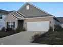 Brick and gray siding ranch home with a white garage door at 4411 Ringstead Way, Indianapolis, IN 46235