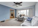 Living room with gray sofa and recliner, ceiling fan, and fireplace at 7041 Weston Ct, Indianapolis, IN 46214