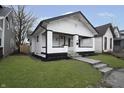 Updated white bungalow with black trim and a welcoming front porch at 1127 E Kelly St, Indianapolis, IN 46203