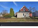 Side view of a red house with beige siding and a small yard at 2402 N B St, Elwood, IN 46036