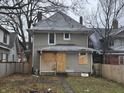 A two-story house with boarded windows and a small backyard at 3609 E Washington St, Indianapolis, IN 46201