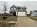 Two-story house with taupe vinyl siding, solar panels, and a spacious driveway at 672 Rocky Meadow Dr, Greenwood, IN 46143