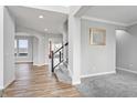 Open entryway with hardwood floors, gray carpeting, and a staircase at 16222 Browning Ct, Fishers, IN 46037