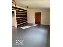 Simple living room with exposed log wall and gray floor at 5967 S Lick Creek Rd, Morgantown, IN 46160