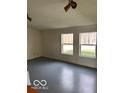 Bright living room with gray floor and two large windows at 5967 S Lick Creek Rd, Morgantown, IN 46160