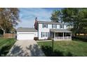 Two-story house with gray siding, blue shutters, and a covered porch at 6031 S Eaton Ave, Indianapolis, IN 46259