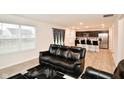 Open concept living room and kitchen with black leather sectional sofa and hardwood floors at 6329 Basden Dr, Indianapolis, IN 46221