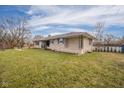 Side view of ranch house, stone exterior, and fenced yard at 2221 E 35Th St, Anderson, IN 46013