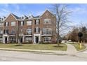 Three-story brick townhouse, featuring balconies and a street view at 11575 Reagan Dr, Fishers, IN 46038