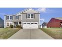 Two-story gray house with white garage door and landscaping at 2034 Buckthorn Dr, Columbus, IN 47201