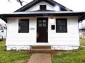 Front view of a charming white house with black door and windows at 1314 Arrow Ave, Anderson, IN 46016