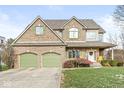 Brick house with two-car garage, landscaping, and a basketball hoop at 685 Greystone Ct, Columbus, IN 47201